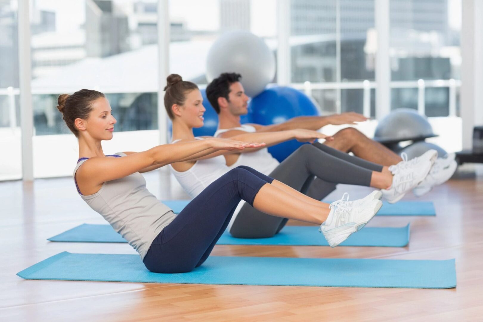 A group of people doing different exercises on mats.