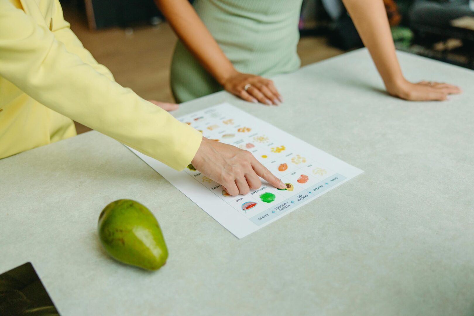 A person is pointing to an image on the table.